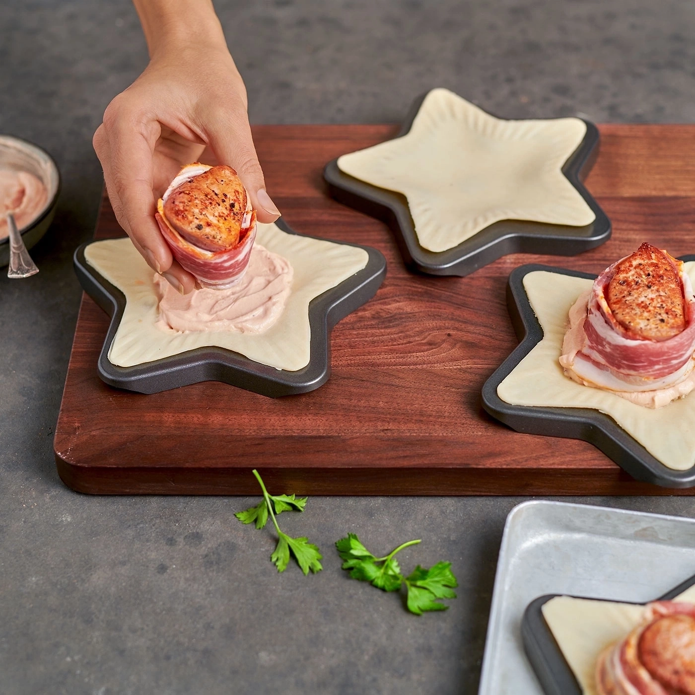 Person legt Fleisch auf Sternform. Essen wird zubereitet. Nahaufnahme.