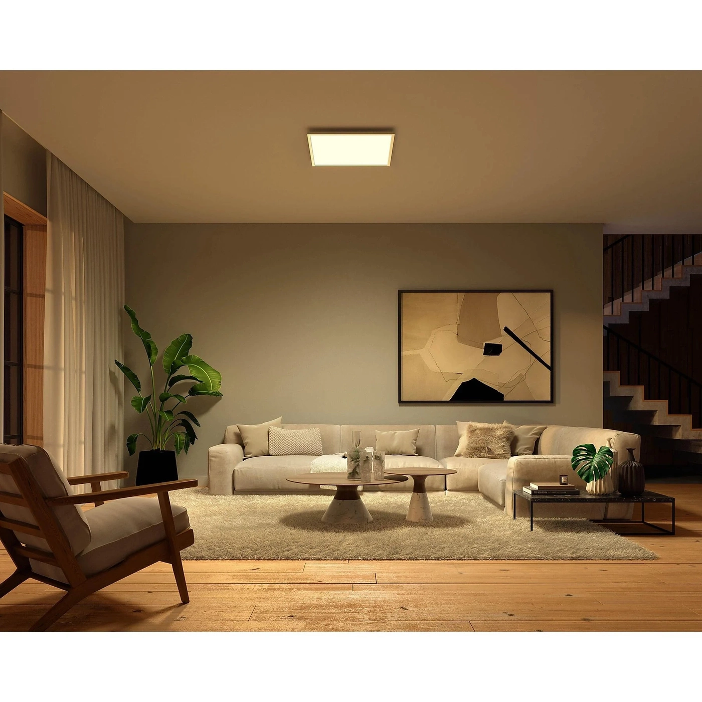 Ein gemütliches Wohnzimmer mit Sofa, Sessel und moderner Kunst.