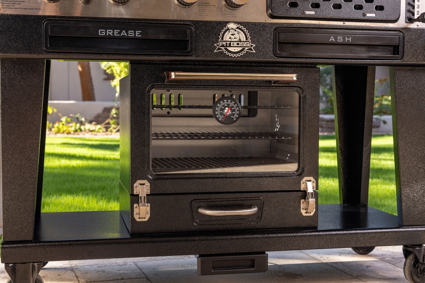 Ein schwarzer Pit Boss Grill mit einem Ofen und einem Thermometer.
