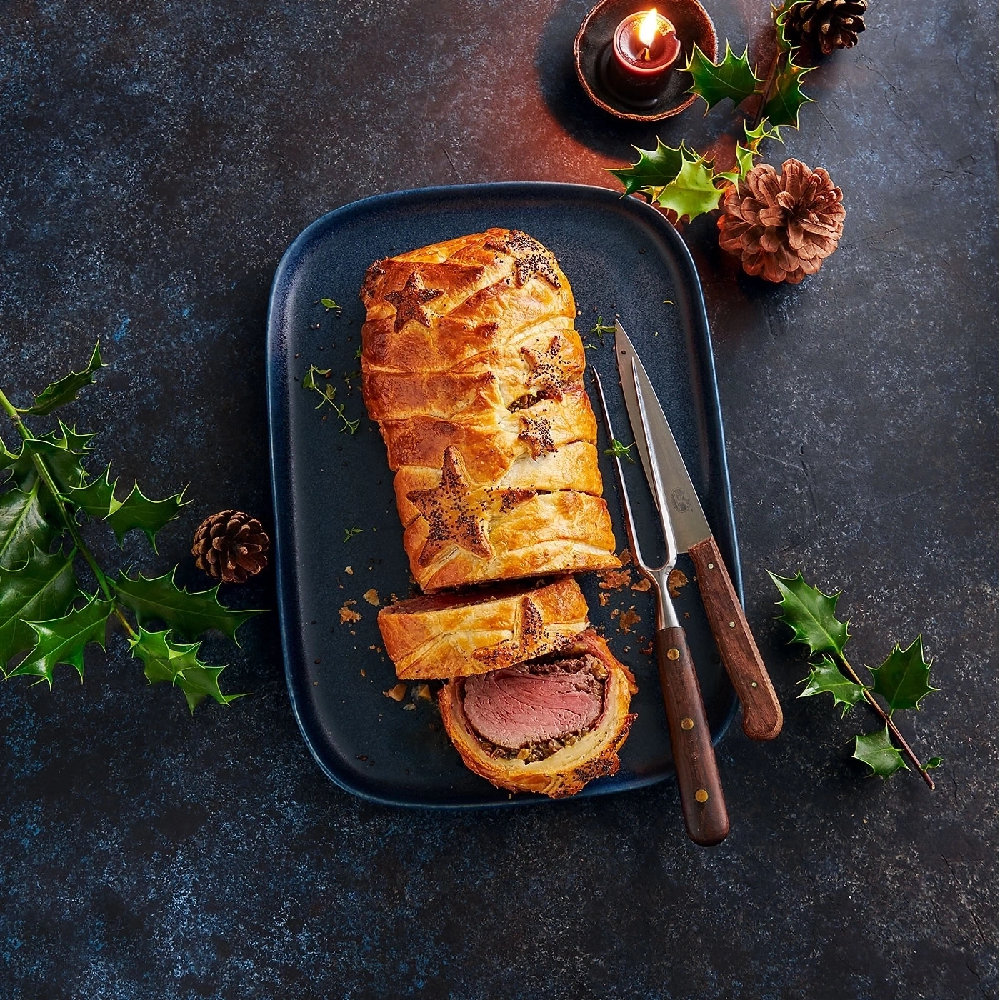 Festliches Gericht: Wellington-Rindfleisch mit Dekoration und Besteck auf einem Teller.