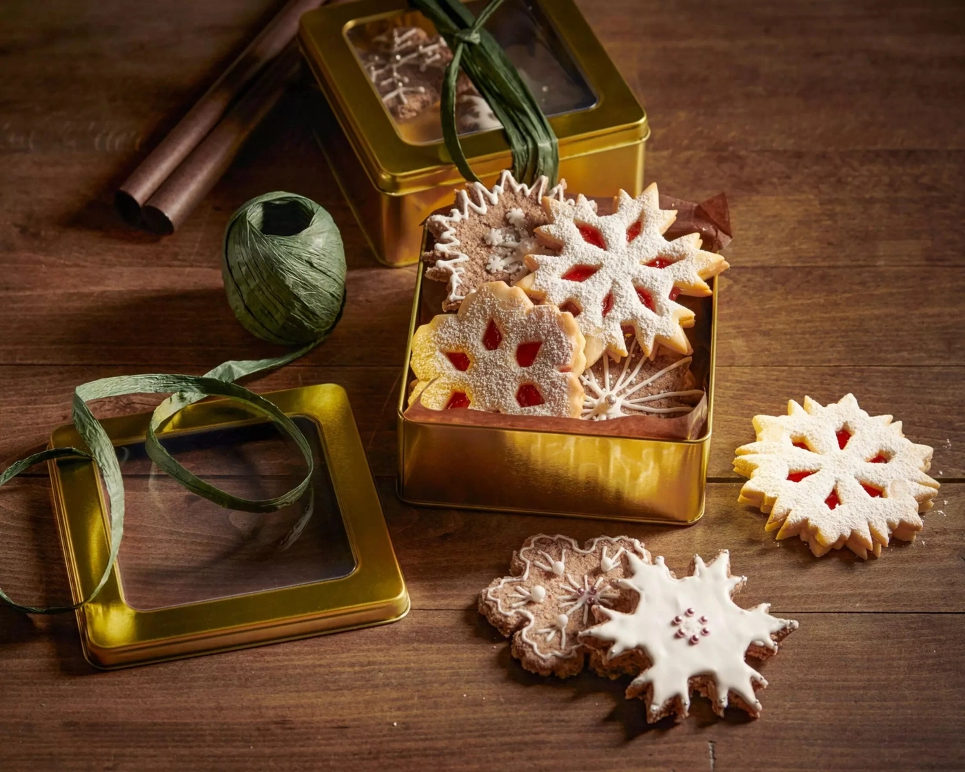 Weihnachtskekse in Sternform in einer goldenen Dose auf Holztisch