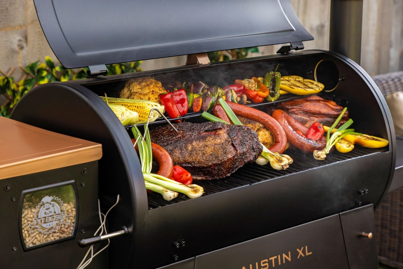 Ein Grill mit Brisket, Würsten, Maiskolben und Gemüse