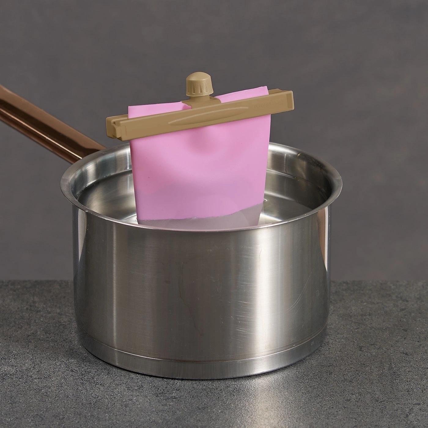 Topf mit Wasser, rosa Beutel mit Clip, Kochutensilien, Küche, grau