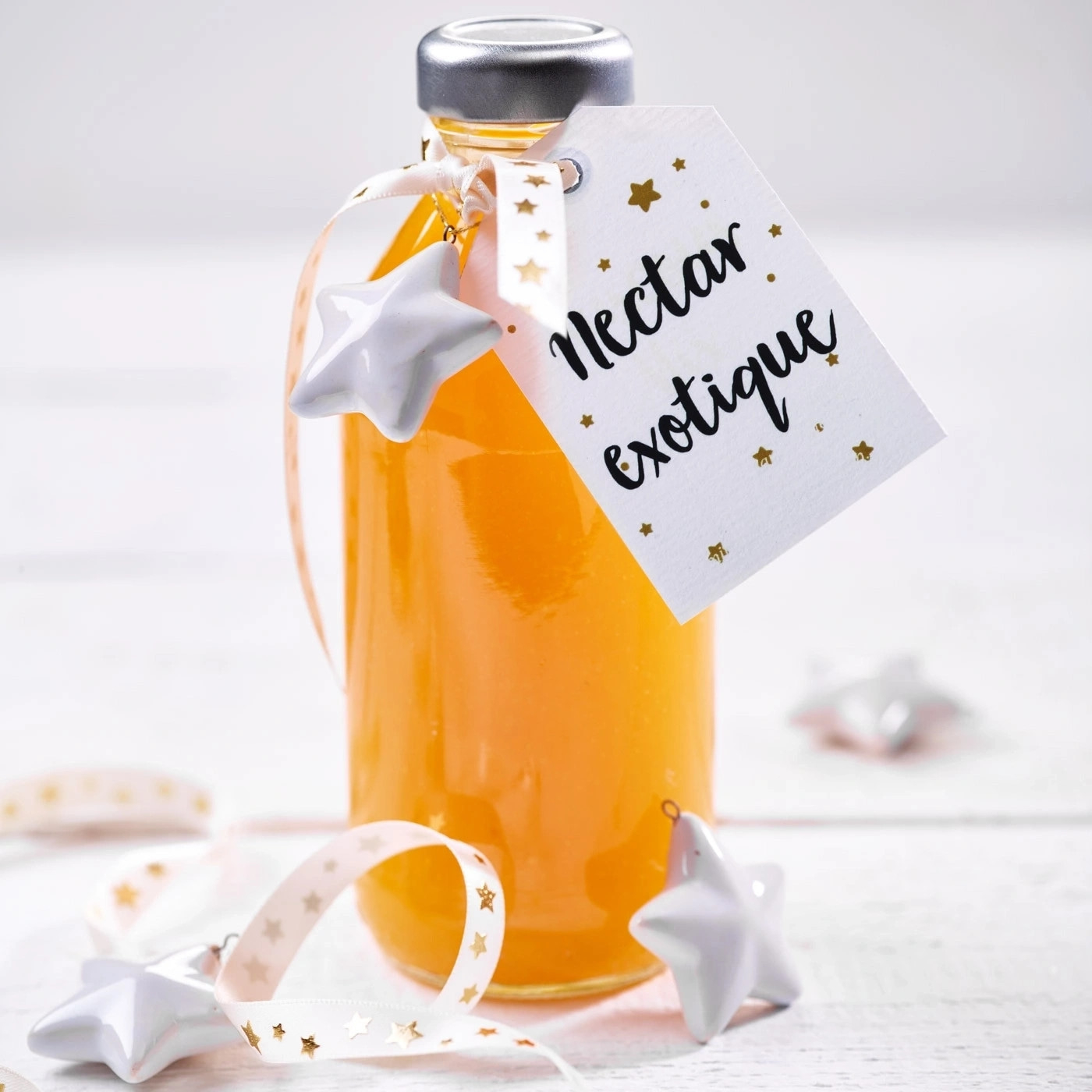 Eine Flasche Nektar mit Sternenanhängern und einem Etikett mit Text.