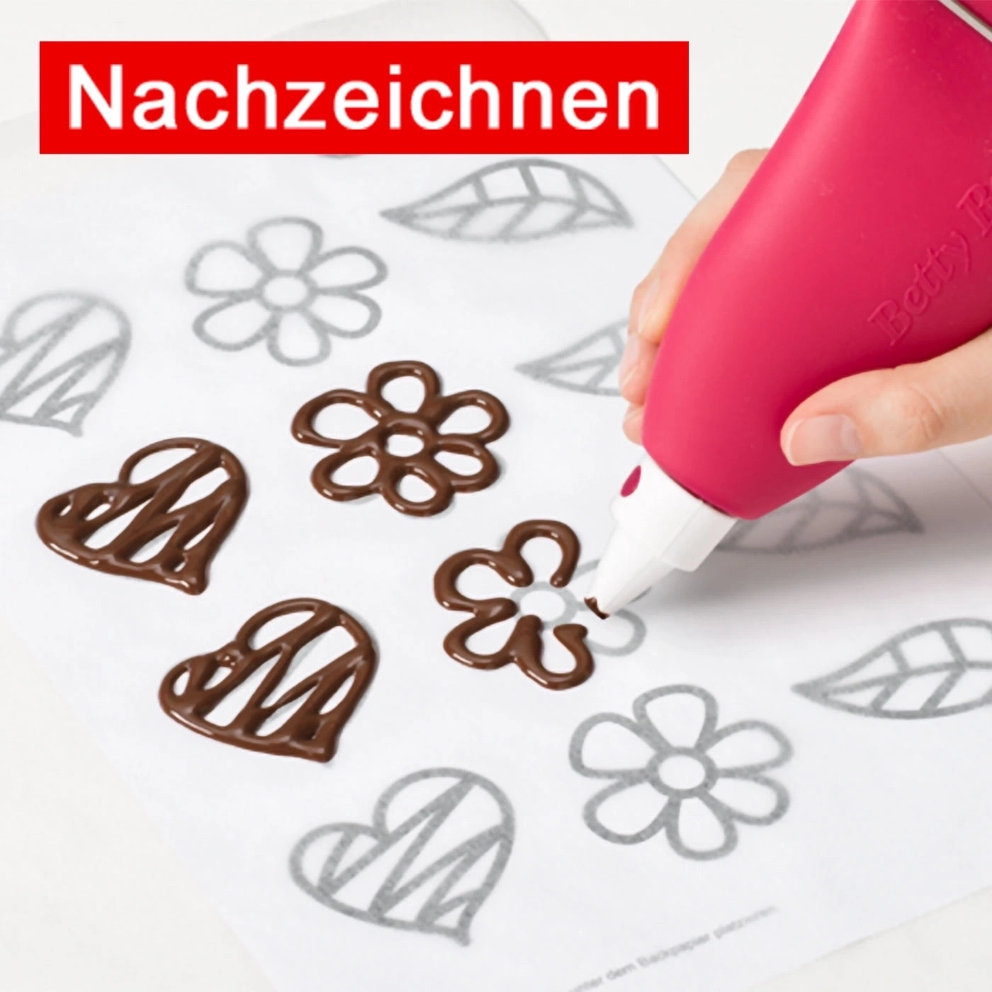Nachzeichnen mit Schokolade: Blumen und Herzen auf Backpapier.