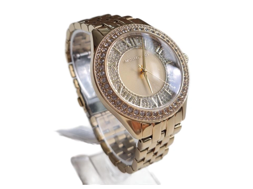 Eine goldene Michael Kors Damenuhr mit Glitzersteinen auf dem Zifferblatt und der Lünette.