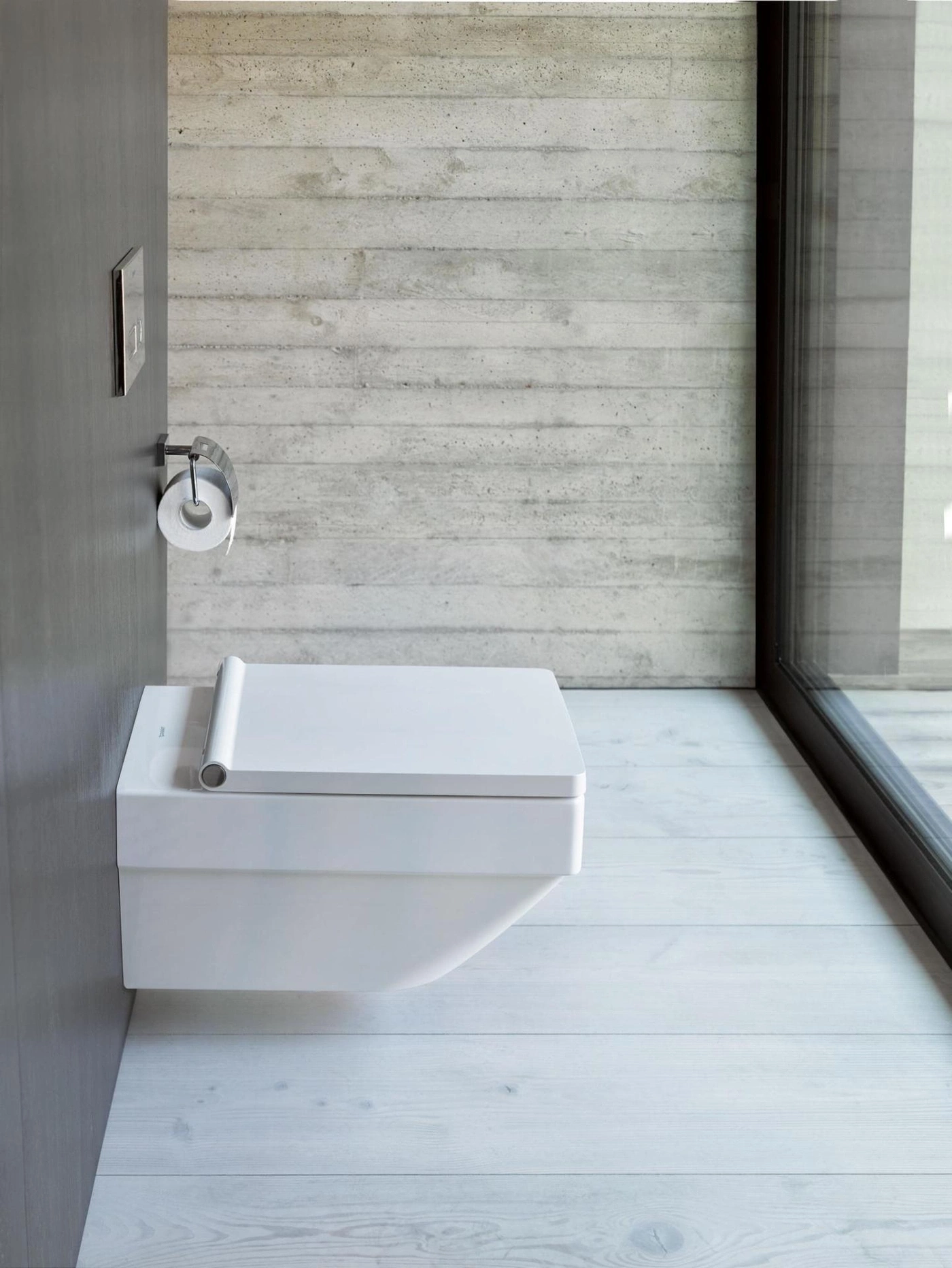 Modernes Badezimmer mit weißer Toilette und Betonwand mit Holzfußboden
