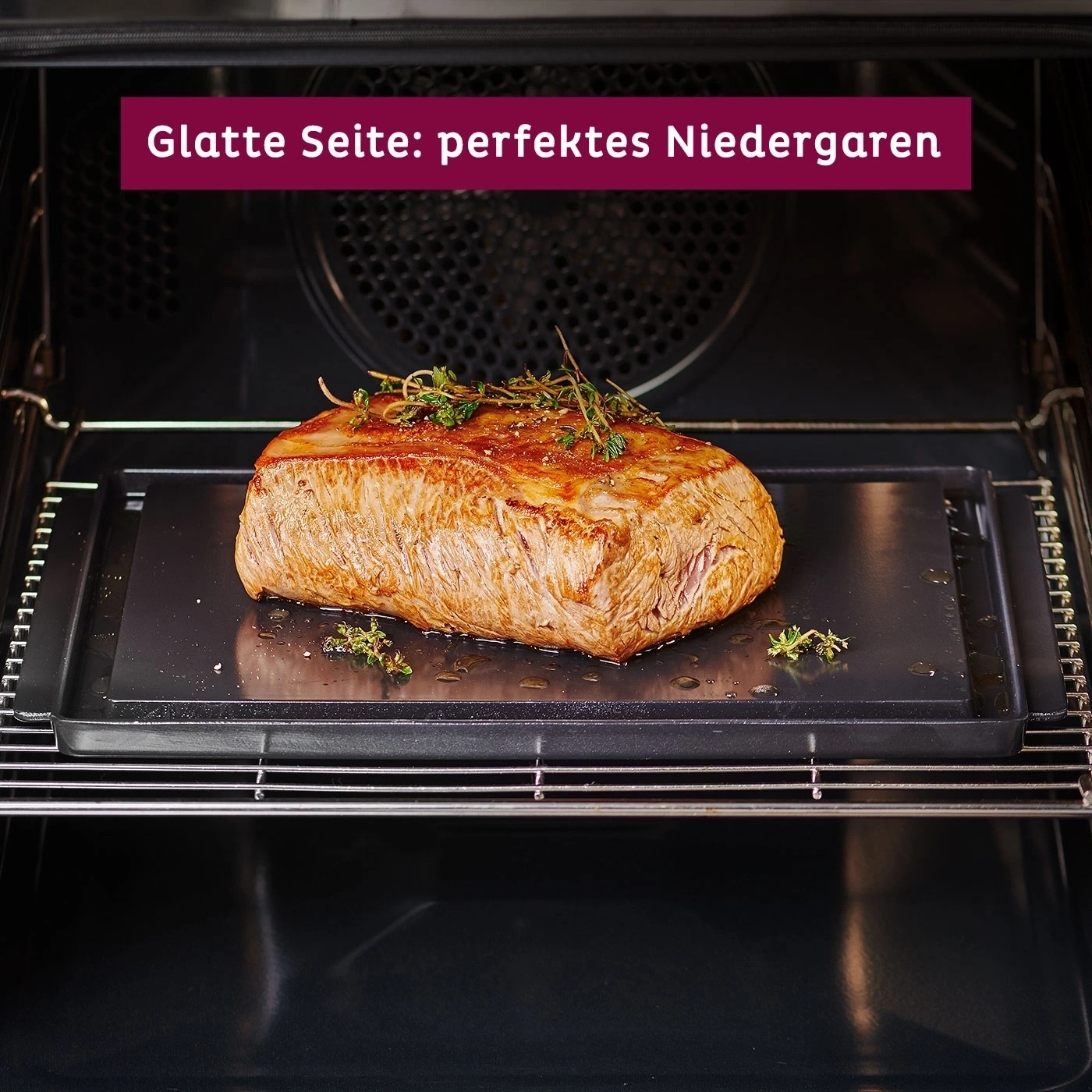 Gebratenes Fleisch im Ofen auf einem schwarzen Tablett. Perfektes Niedergaren.