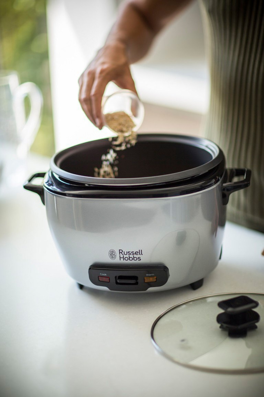 Person gießt Zutaten in einen Reiskocher von Russell Hobbs, Küche, Kochen