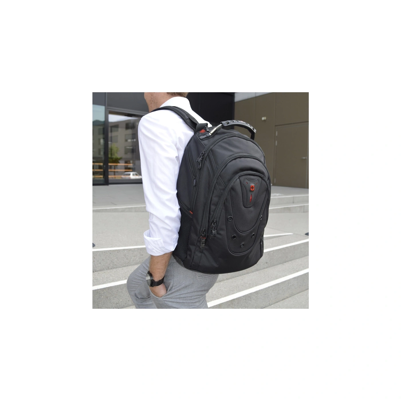 Mann mit schwarzem Rucksack auf Treppe, weißes Hemd, graue Hose, Uhr