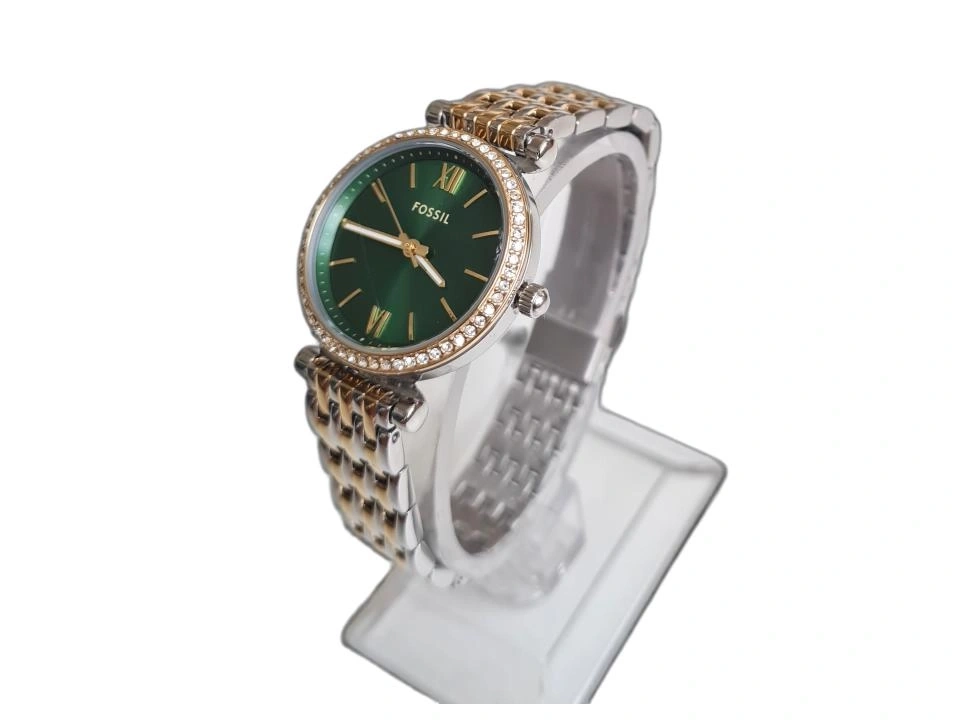 Eine Fossil Damenuhr mit grüner Zifferblatt und bicolor Armband auf einem Ständer.