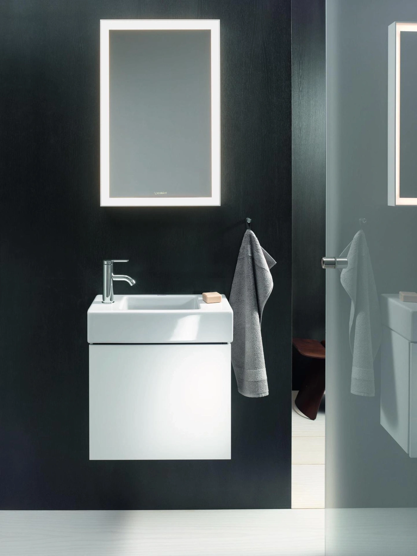 Modernes Badezimmer mit Waschbecken, Spiegel und Handtuch