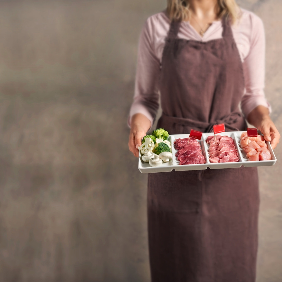 Person hält Tablett mit Fleisch und Gemüse, Nahaufnahme