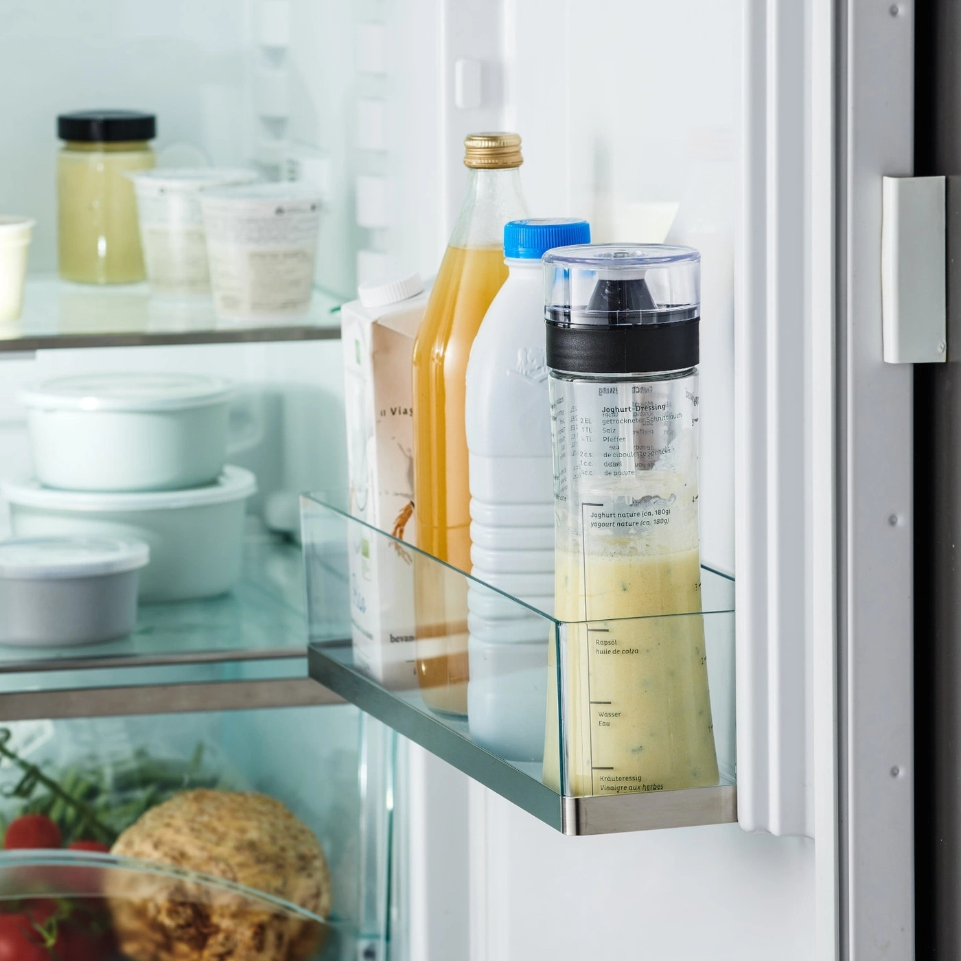 Kühlschrank mit Dressing, Saft und Milch. Gemüse und Obst im Kühlschrank.