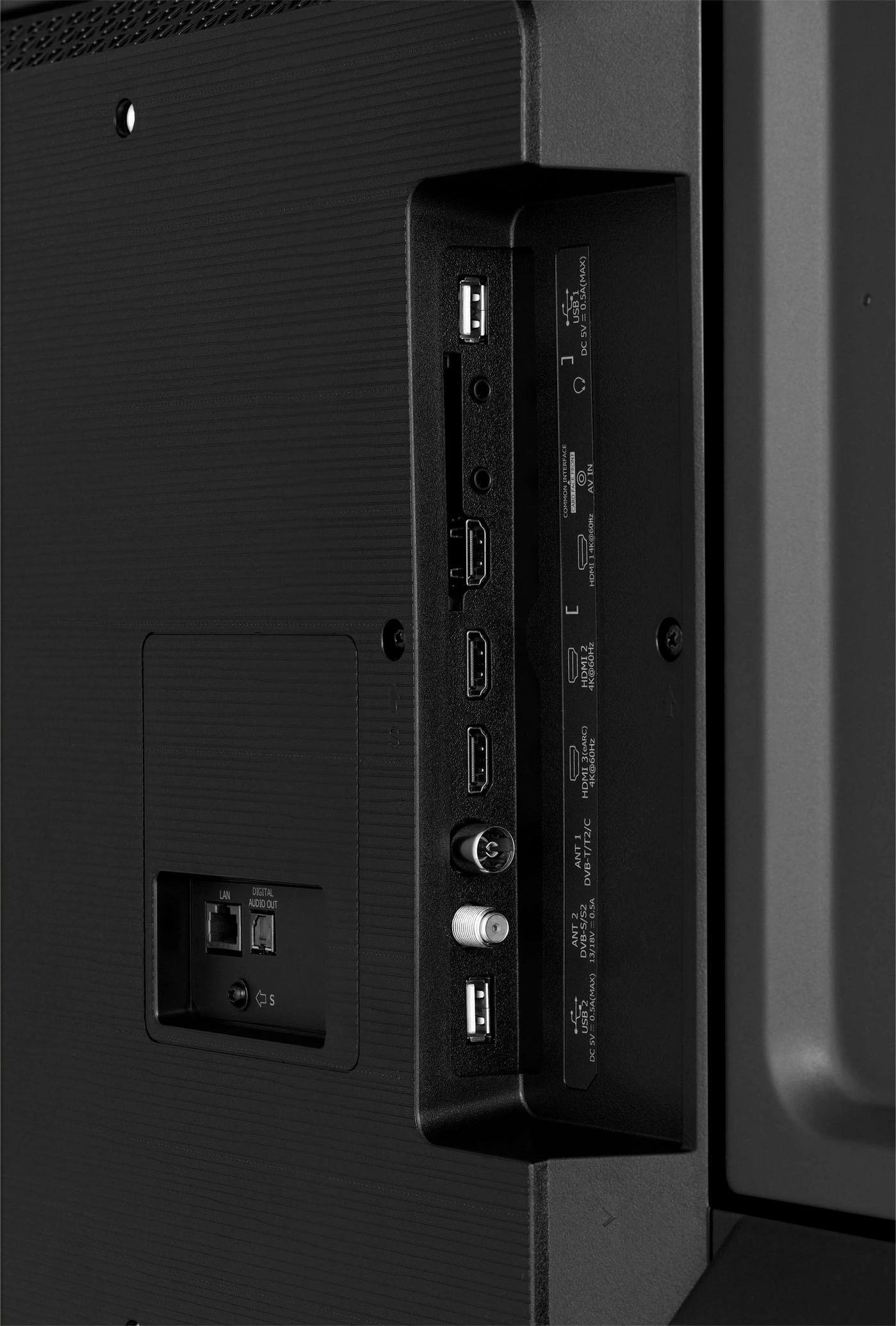 Nahaufnahme der Anschlüsse an der Rückseite eines schwarzen Fernsehers mit HDMI- und USB-Anschlüssen