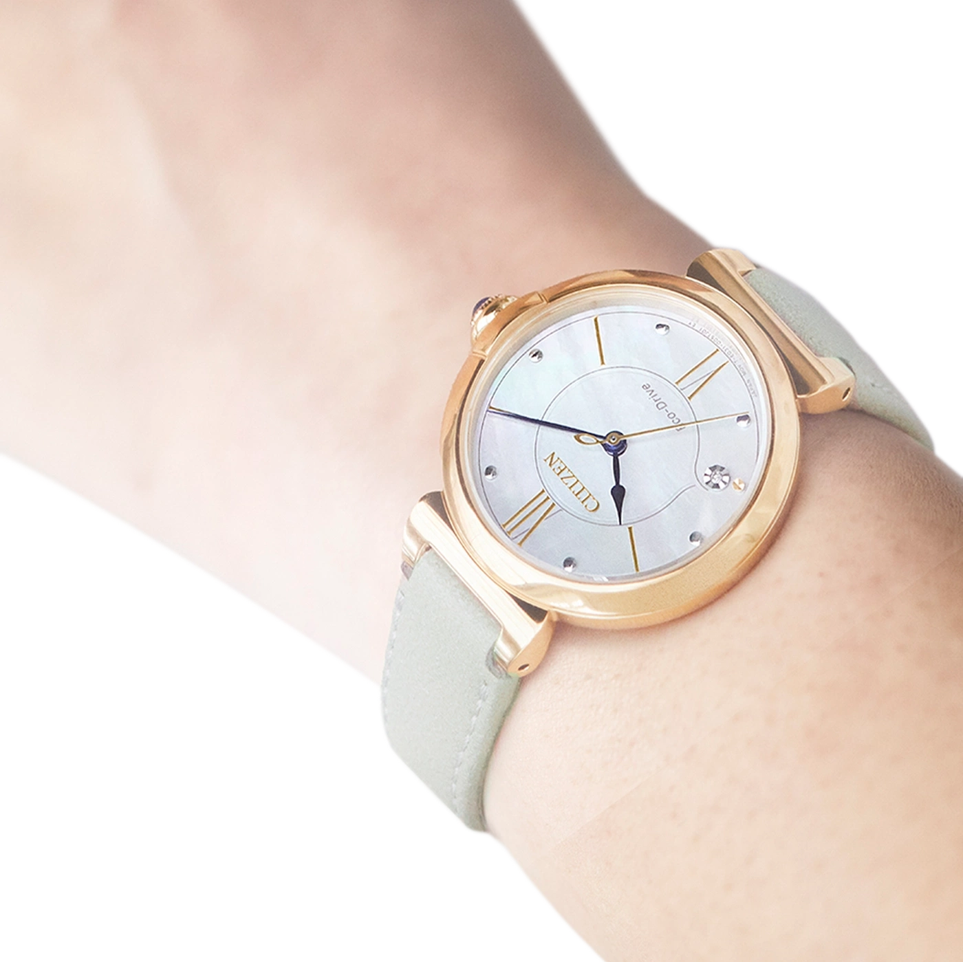 Nahaufnahme einer goldenen Citizen-Uhr mit hellgrünem Armband am Handgelenk