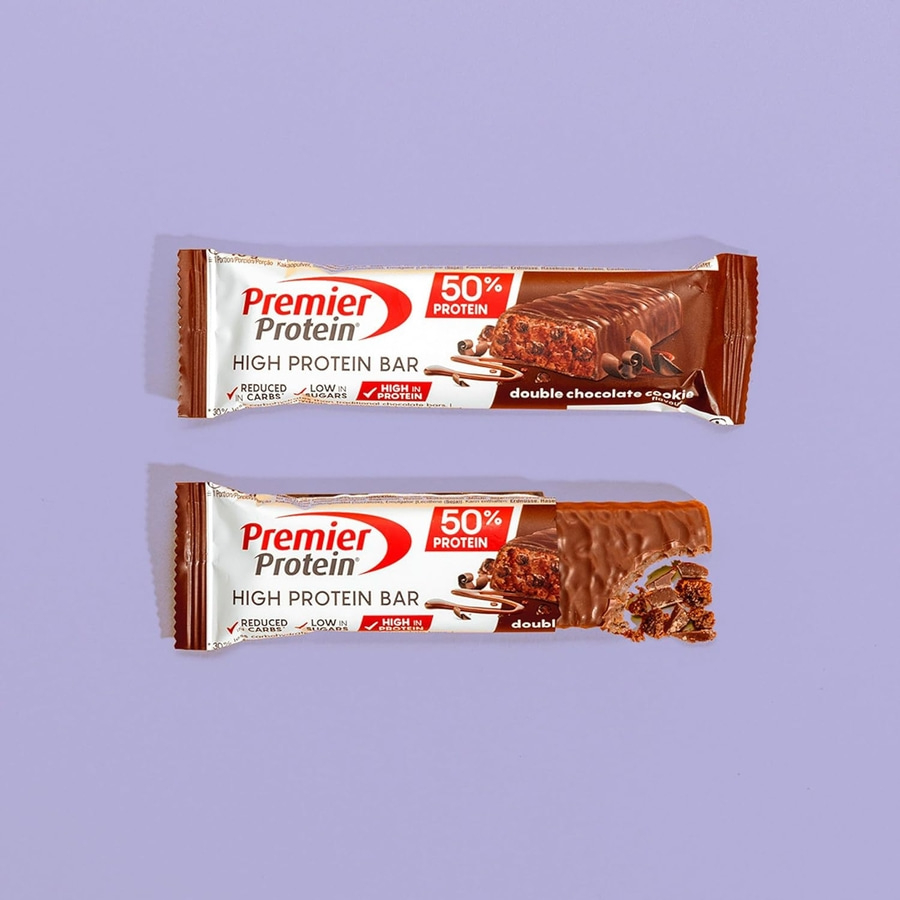 Zwei Premier Protein Riegel mit Schokoladengeschmack auf lila Hintergrund