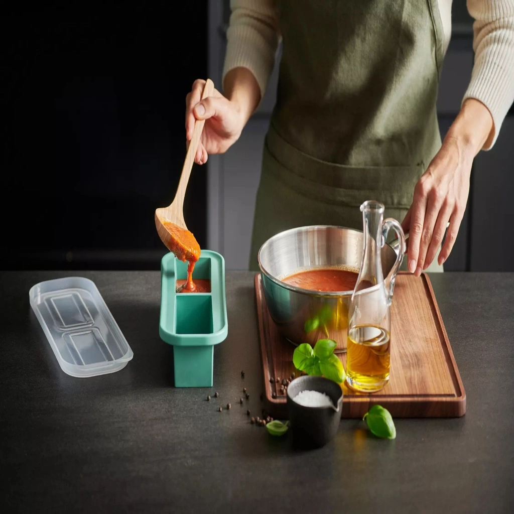 Tomatensoße wird in ein
Eiswürfel
beh
ilter gef
illet