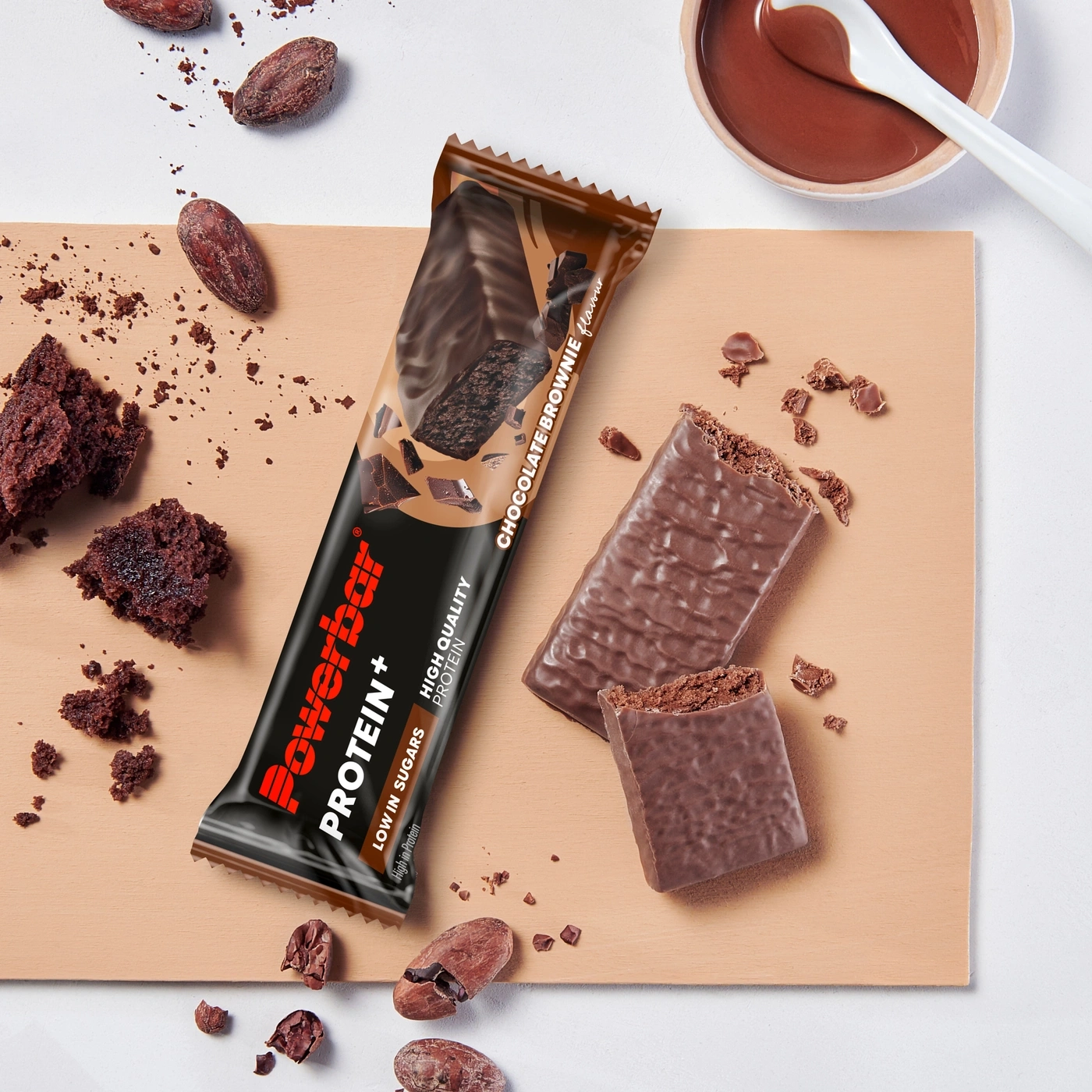 Schokoriegel mit Brownie-Geschmack und Kakao auf Holzbrett