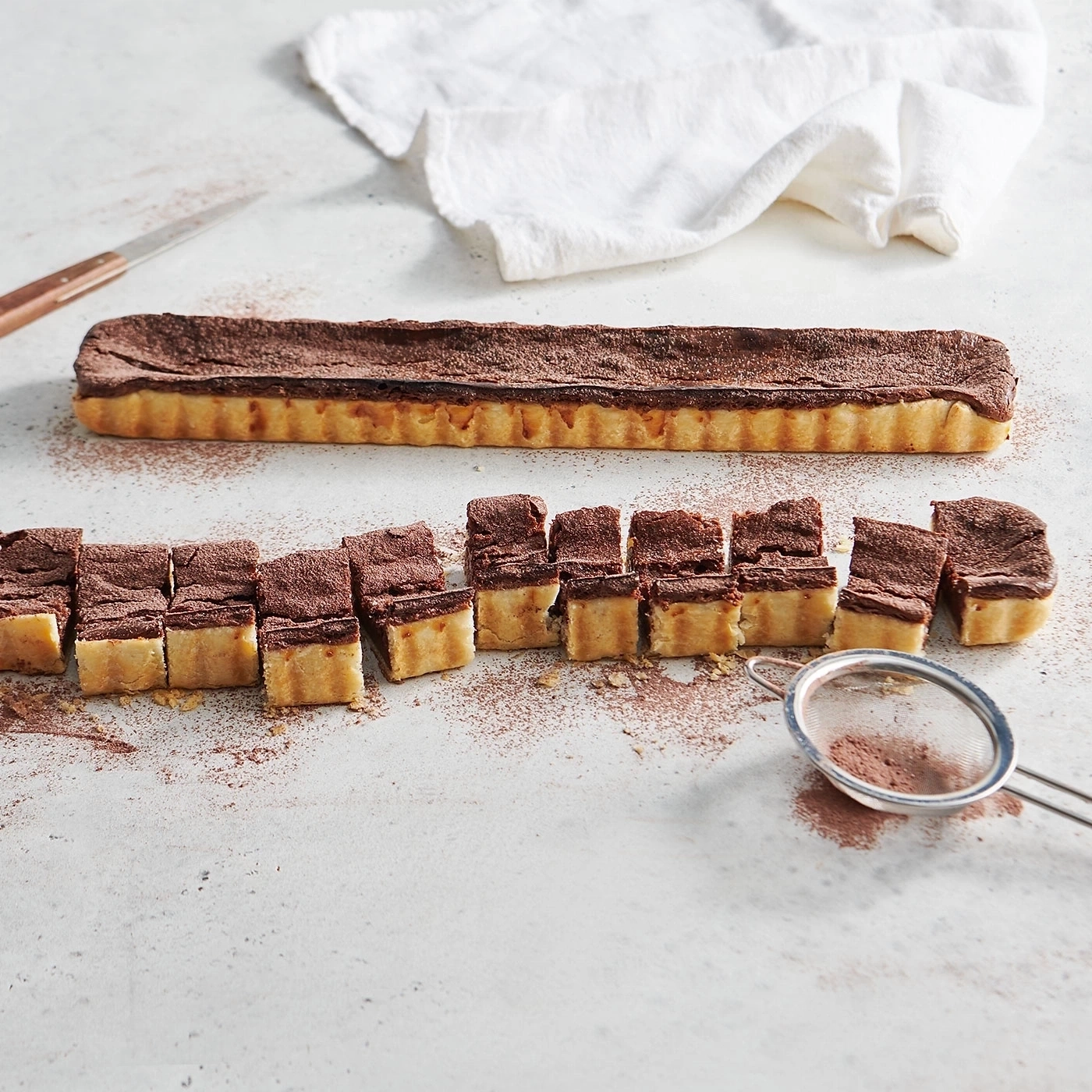Schokoladenkuchen mit Kakaopulver bestreut, in Scheiben geschnitten