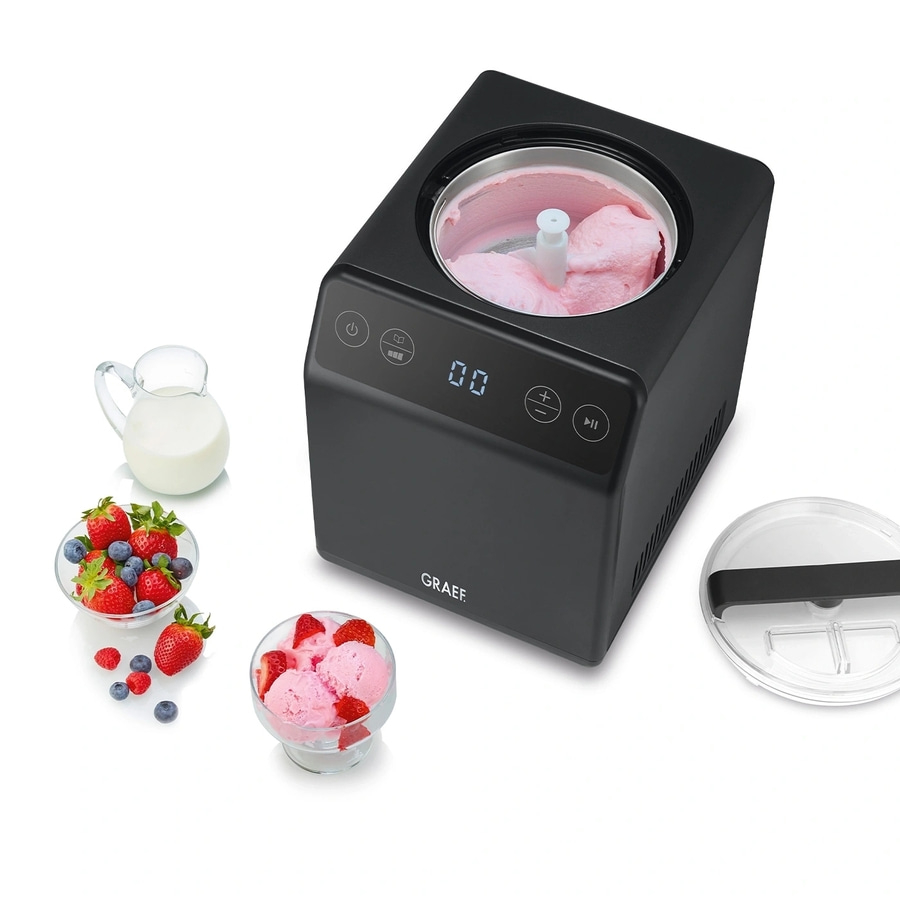 Eismaschine mit Eis, Früchten und Milch. Schwarze Maschine mit Deckel.
