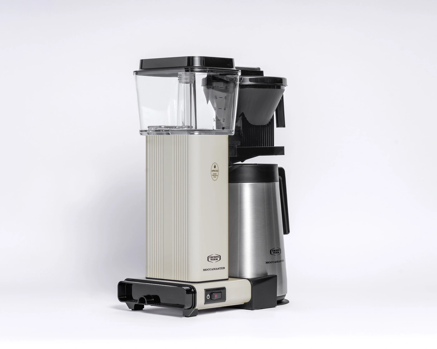 Eine cremefarbene Kaffeemaschine mit Thermoskanne und schwarzem Oberteil.