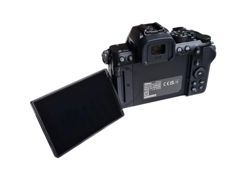 Rückseite einer Nikon Z 50 Digitalkamera mit aufgeklapptem LCD-Bildschirm und verschiedenen Beschriftungen und Logos.
