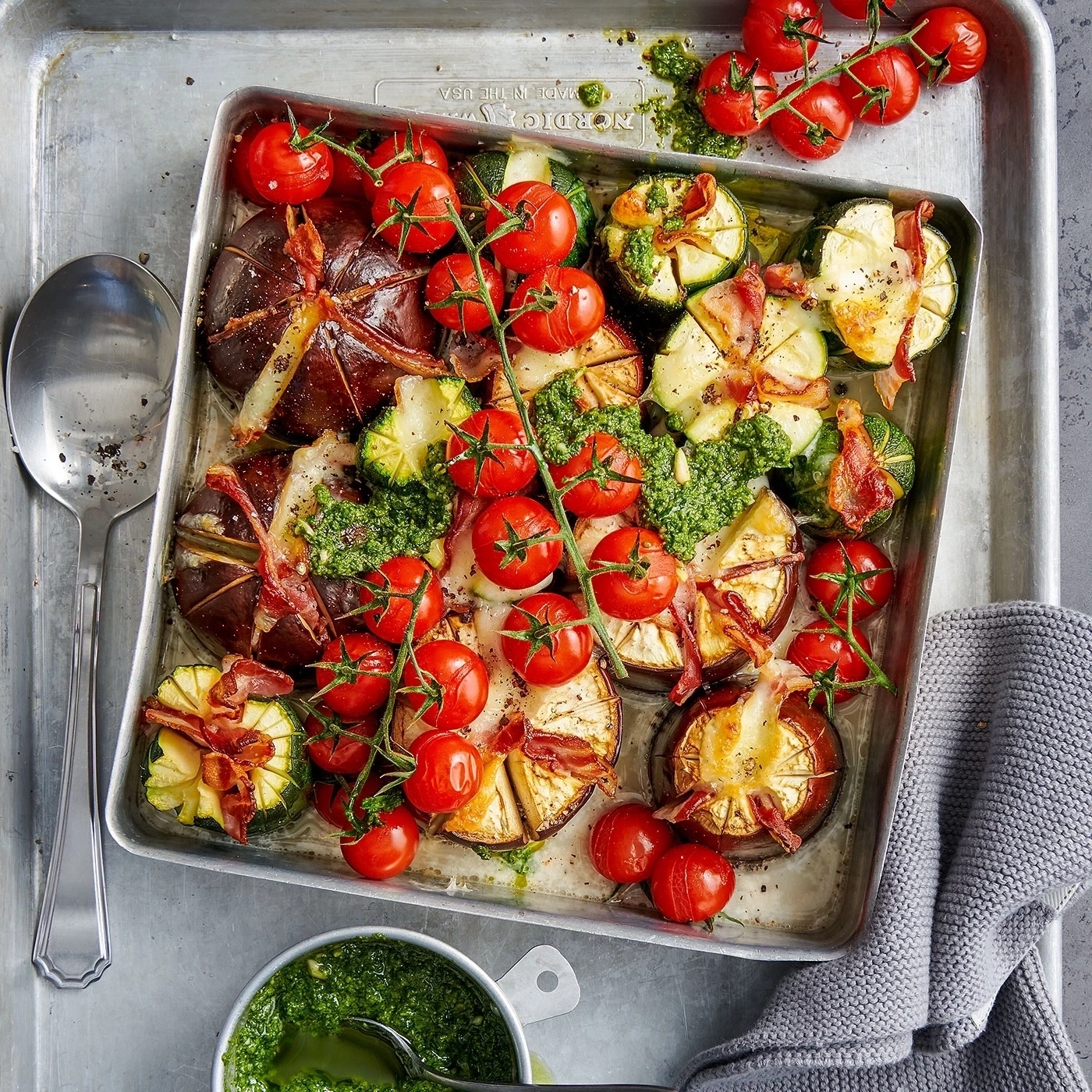 Gebratene Tomaten, Zucchini, Feigen und Speck auf einem Tablett mit Pesto.