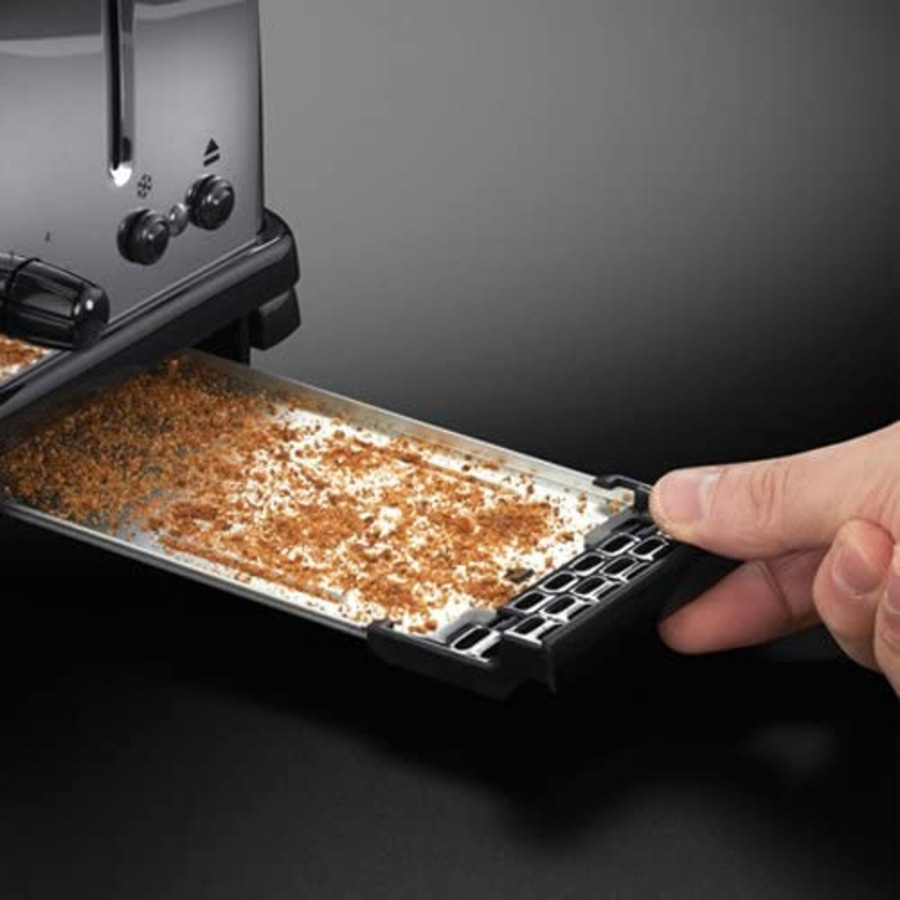 Toaster mit Krümelschublade, die von einer Hand herausgezogen wird, um sie zu reinigen.