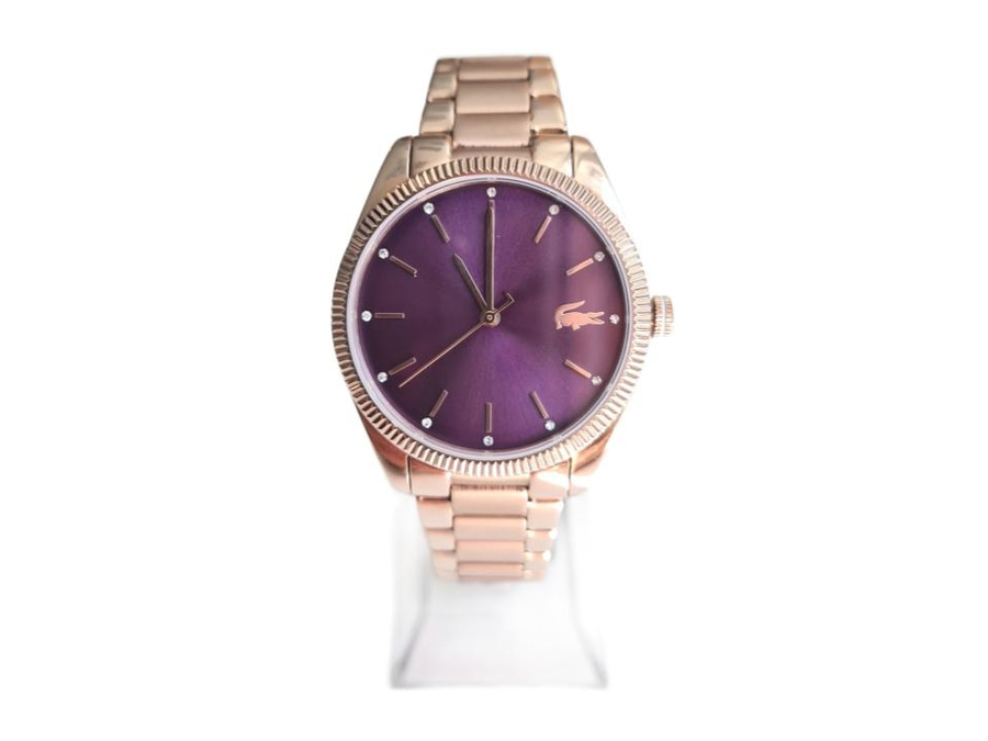 Eine roséfarbene Lacoste-Armbanduhr mit violettem Zifferblatt und silbernen Akzenten.