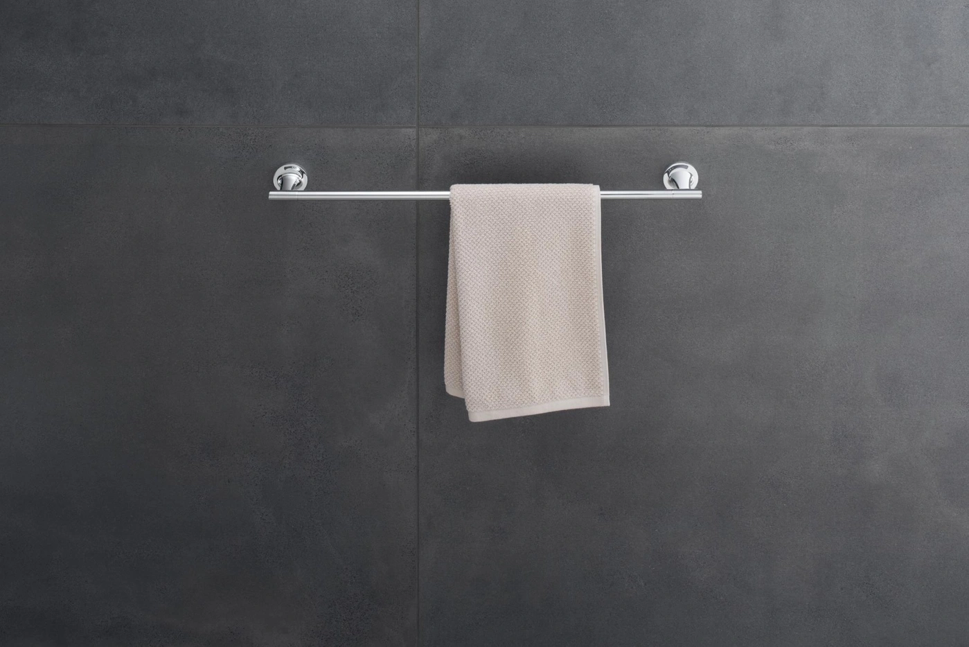 Handtuch an einer silbernen Stange vor dunkler Wand