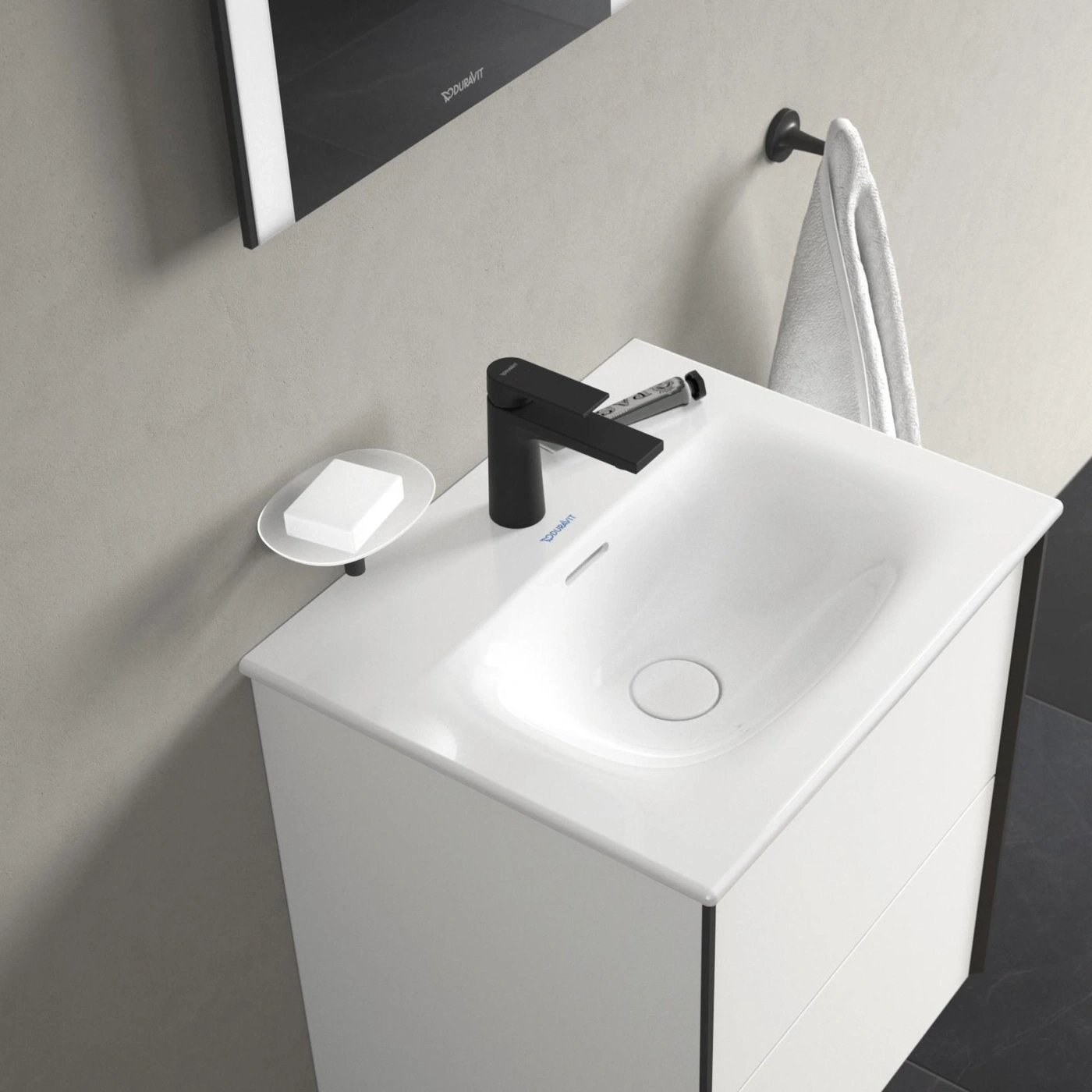 Weißes Waschbecken mit schwarzer Armatur und Seifenschale im Badezimmer