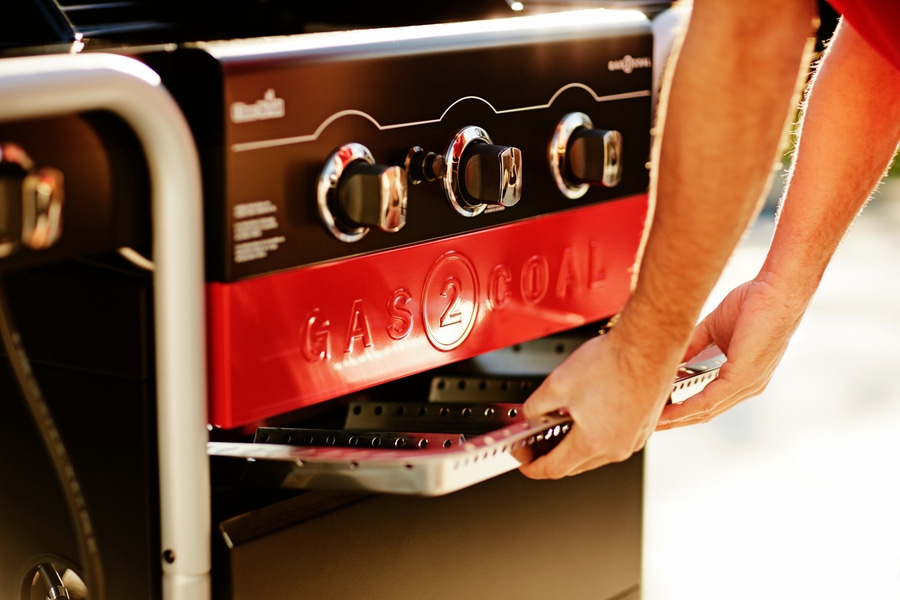 Nahaufnahme eines Mannes, der einen Grill bedient, mit roter und schwarzer Farbe.