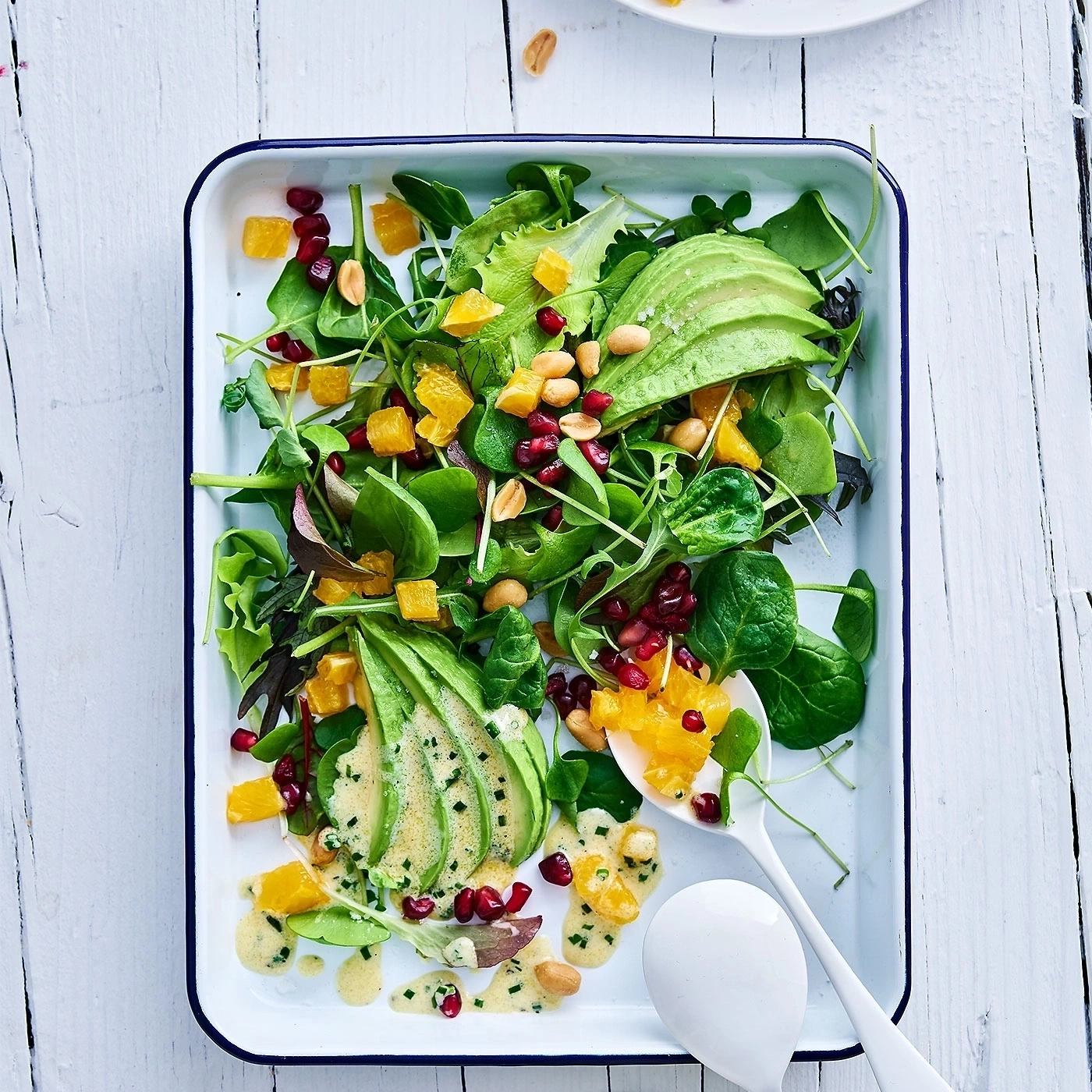 Frischer Salat mit Avocado, Orangen, Granatapfelkernen und Erdnüssen