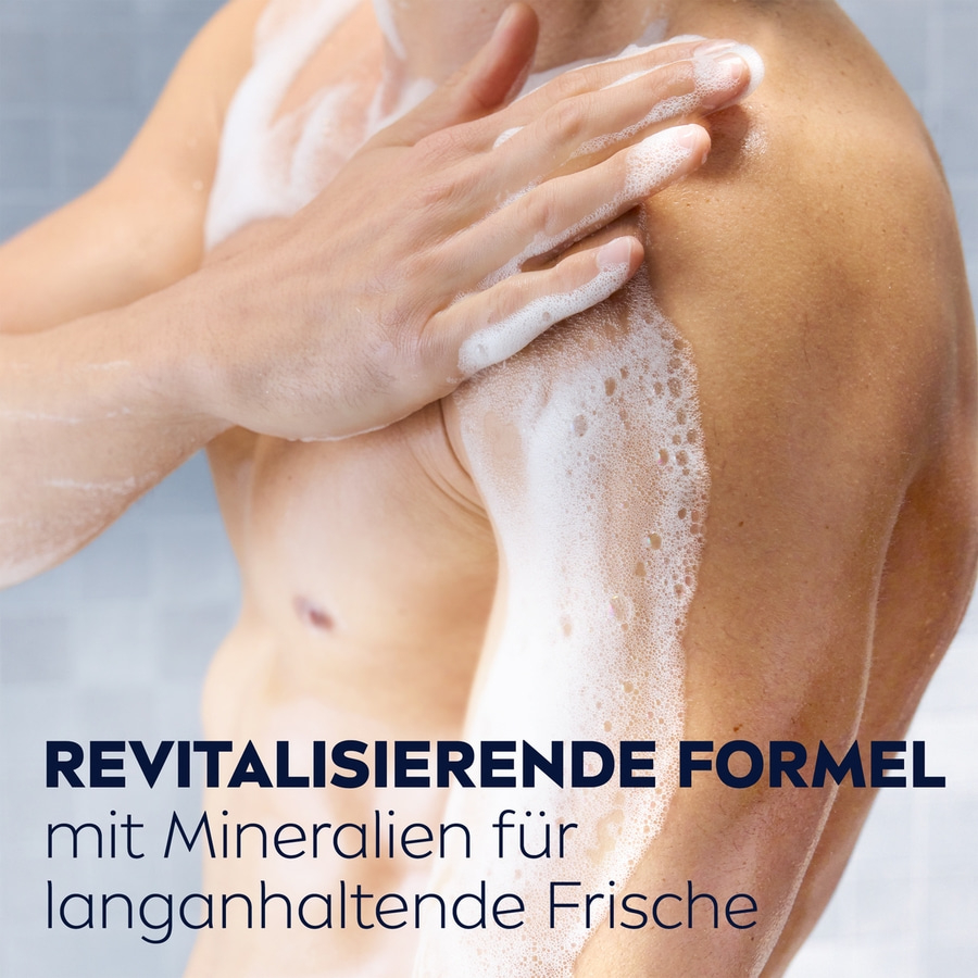 Mann duscht sich mit Seife. Schaum auf der Haut. Text: revitalisierende Formel.