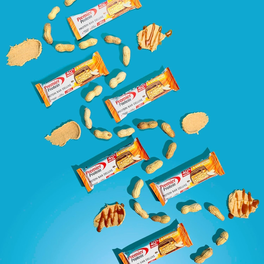 Premier Protein Riegel mit Erdnüssen und Karamell auf blauem Hintergrund