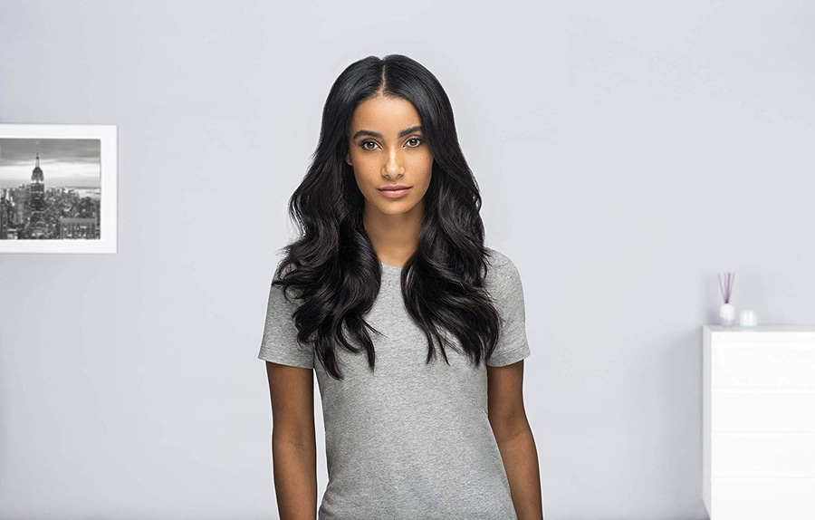 Junge Frau mit langen, schwarzen Haaren, die ein graues T-Shirt trägt.