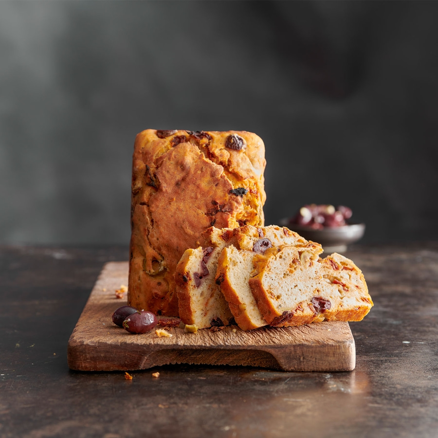 Brot mit Oliven auf einem Holzbrett, geschnitten, Nahaufnahme