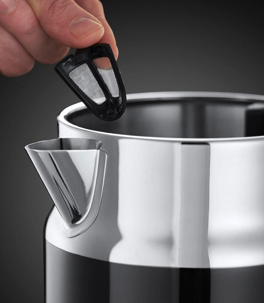 Nahaufnahme eines Wasserkochers mit herausnehmbarem Filter, der von einer Hand gehalten wird.