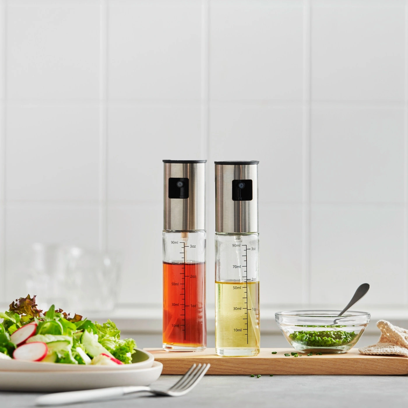 Öl- und Essigspender mit Salat und Dressing auf Holzbrett