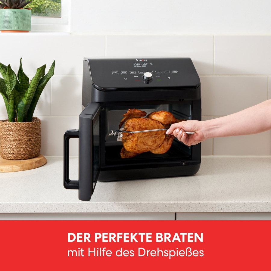 Ein Ofen mit einem Braten, der mit Hilfe des Drehspießes zubereitet wird.