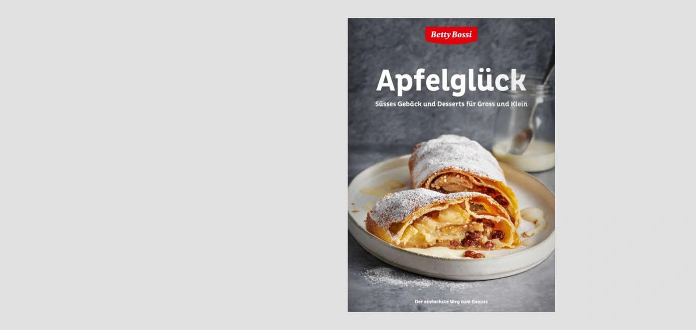 Buch "Apfelglück" mit einem Apfelstrudel auf einem Teller.