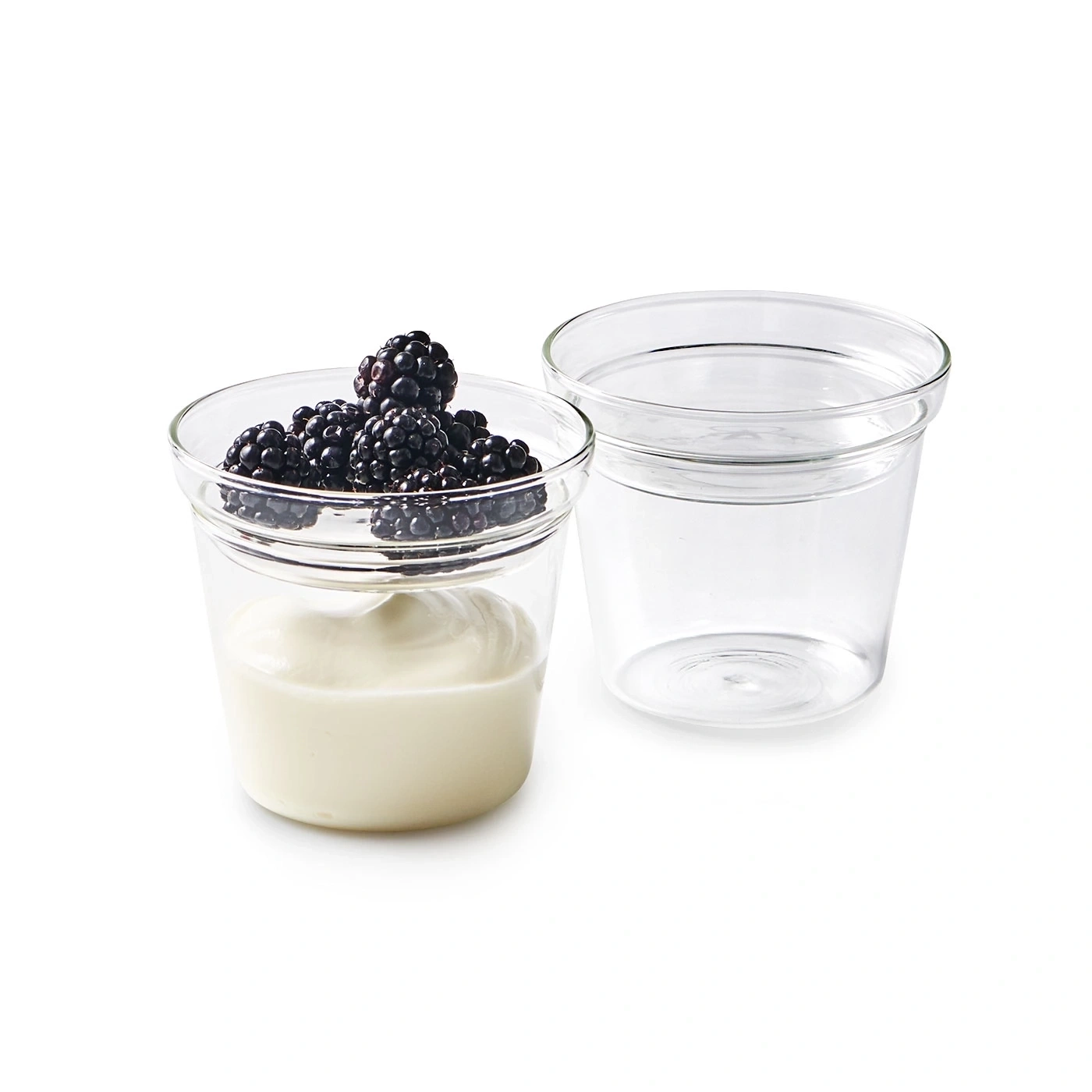 Zwei Gläser mit Joghurt und Brombeeren, isoliert auf weißem Hintergrund