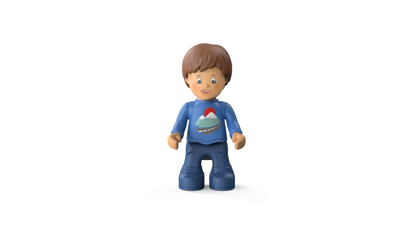 Spielzeugfigur eines Jungen mit blauem Shirt und Hose, vor weißem Hintergrund