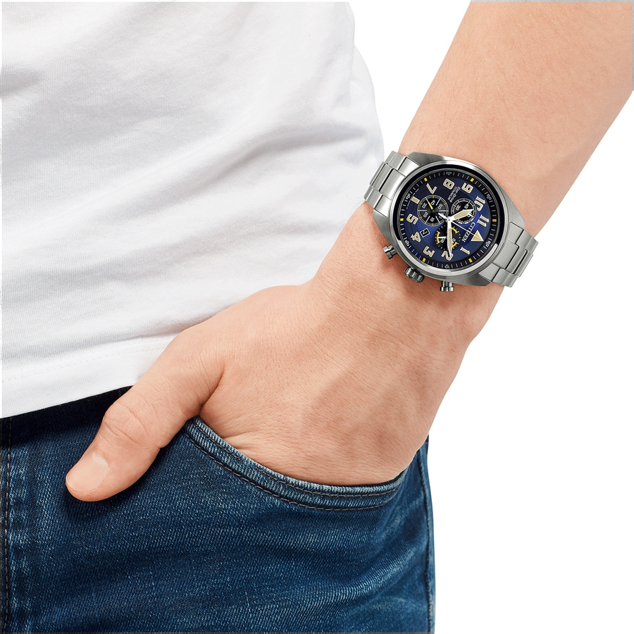 Mann mit Uhr, Jeans und weißem T-Shirt, die Hand in der Hosentasche