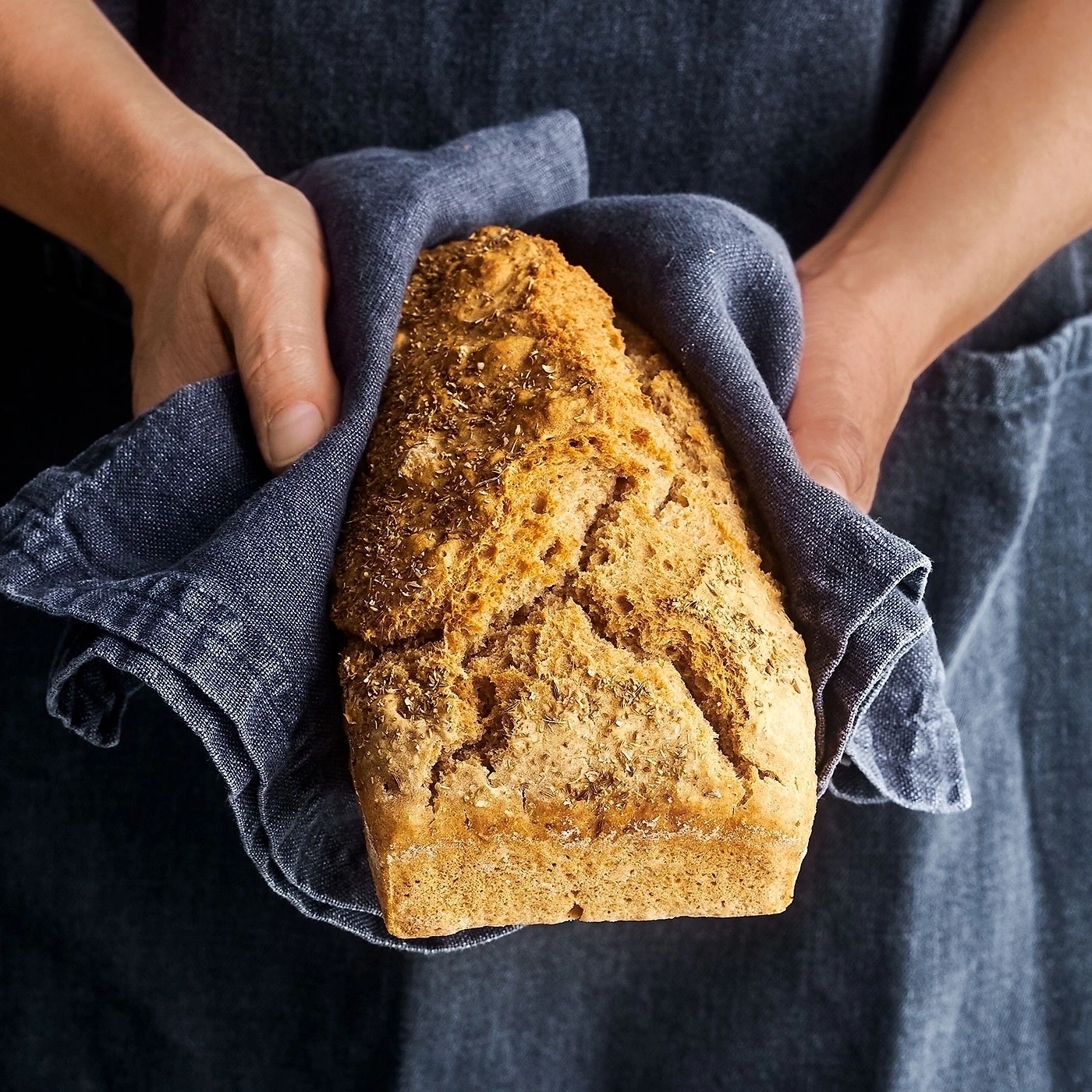 Person hält Brot in einem blauen Tuch, Nahaufnahme, Essen, Backen
