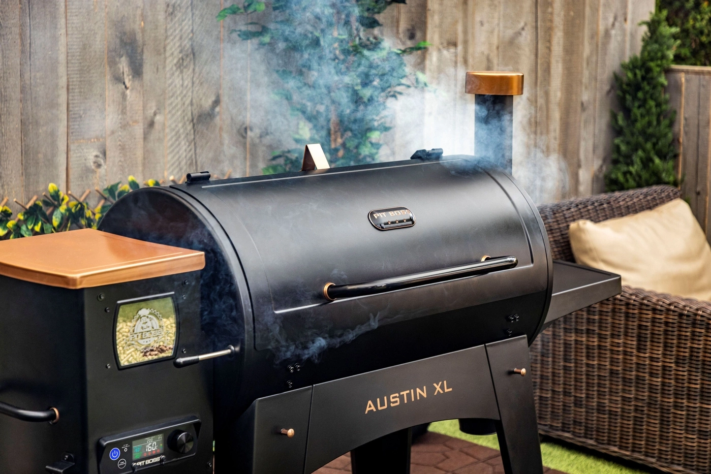 Schwarzer Pit Boss Austin XL Grill mit Rauch und Kupferdetails