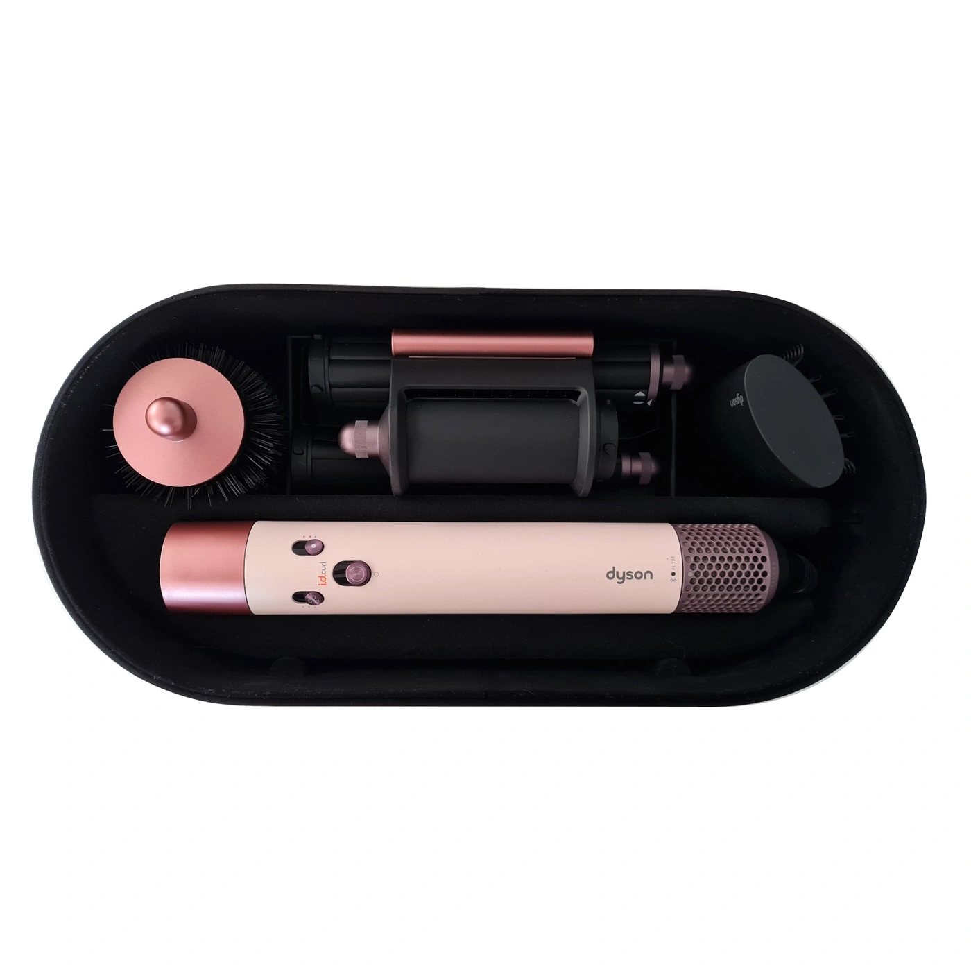 Ein rosa Dyson Haarglätter mit Zubehör in einem schwarzen Koffer
