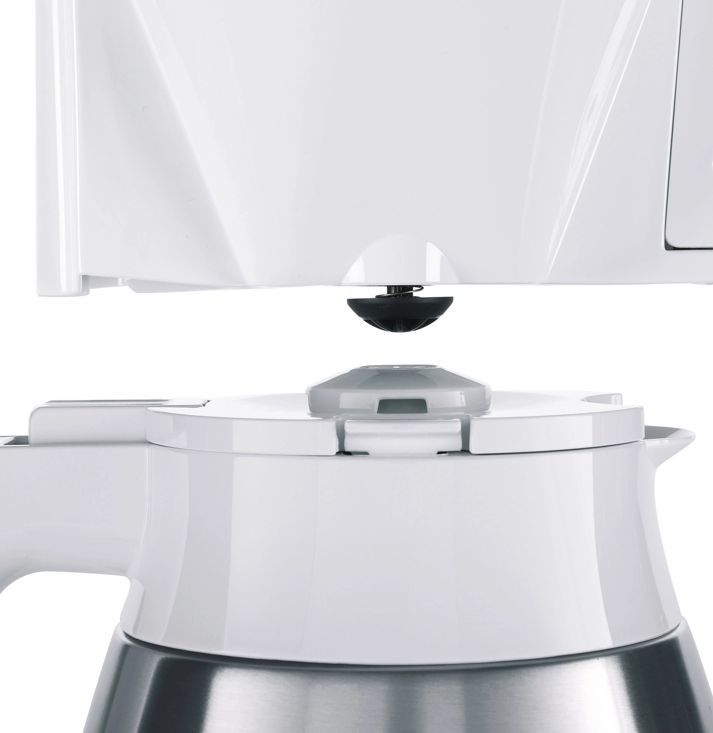 Nahaufnahme eines weißen Kaffeemaschinenkrugs mit Metallboden.