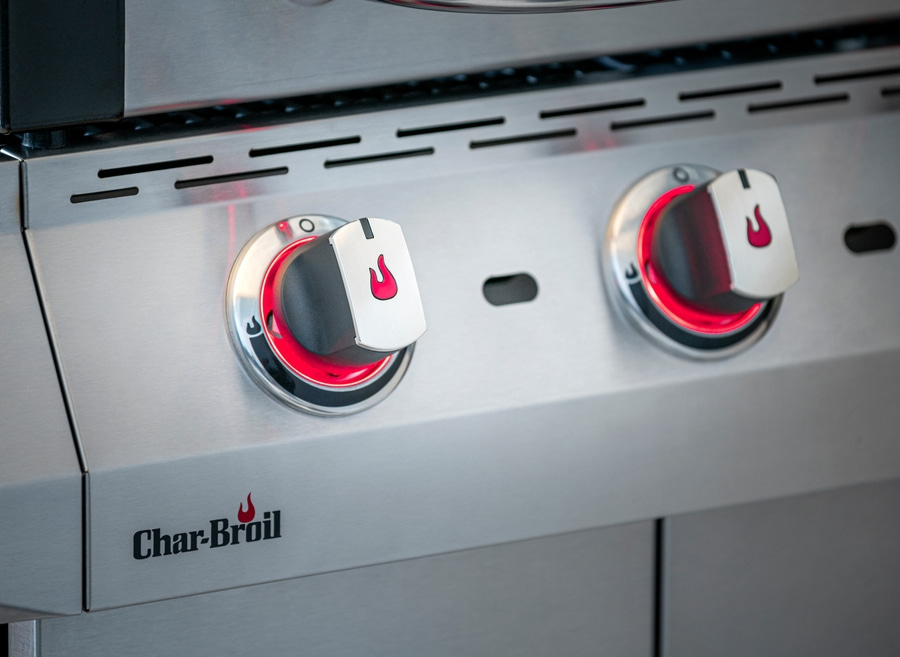 Nahaufnahme von Grillknöpfen mit roter Beleuchtung und Char-Broil-Logo.